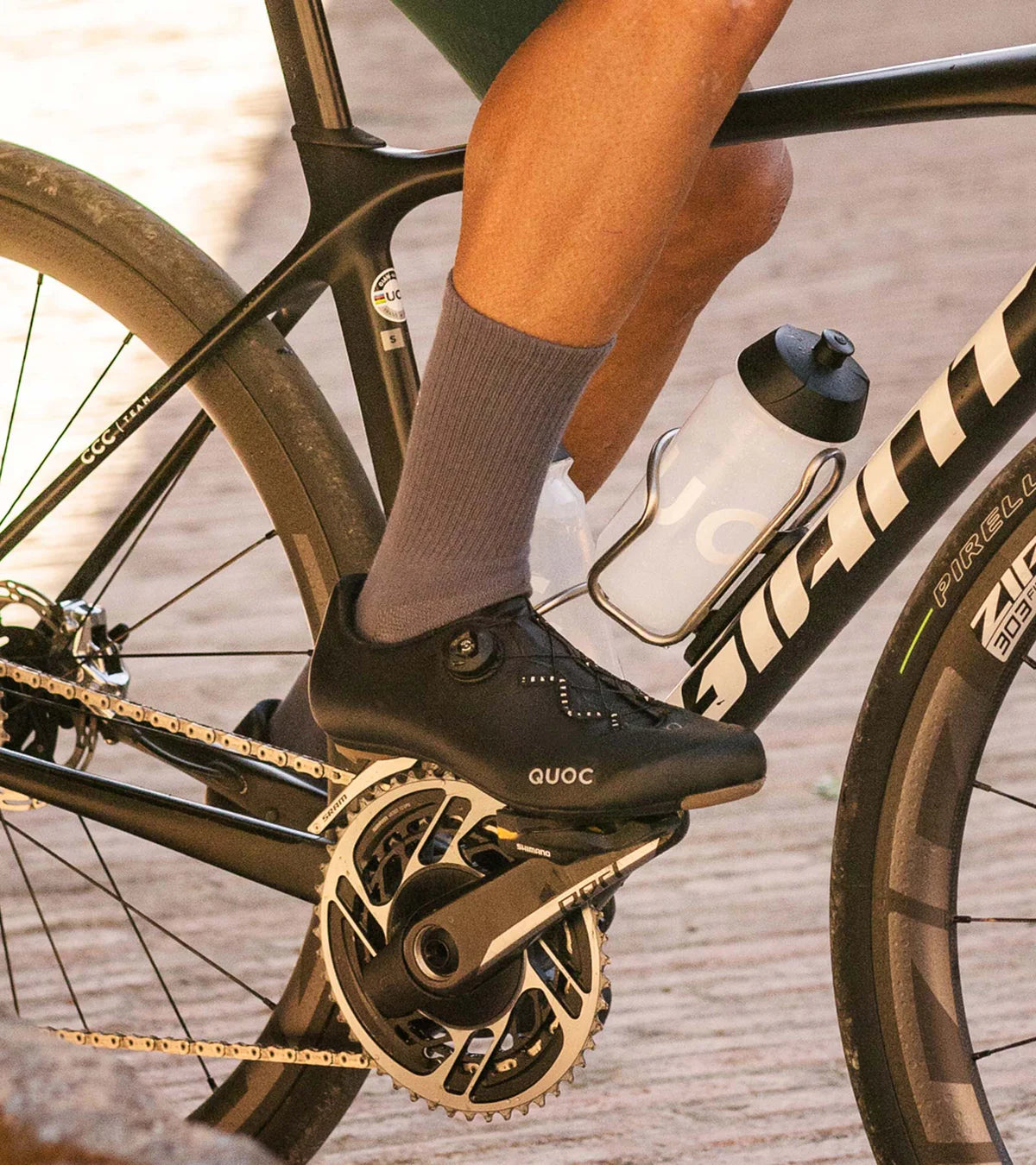 Cyclist wearing QUOC Escape Road Shoe in black while pedaling, highlighting comfort and power transfer on a road bike.