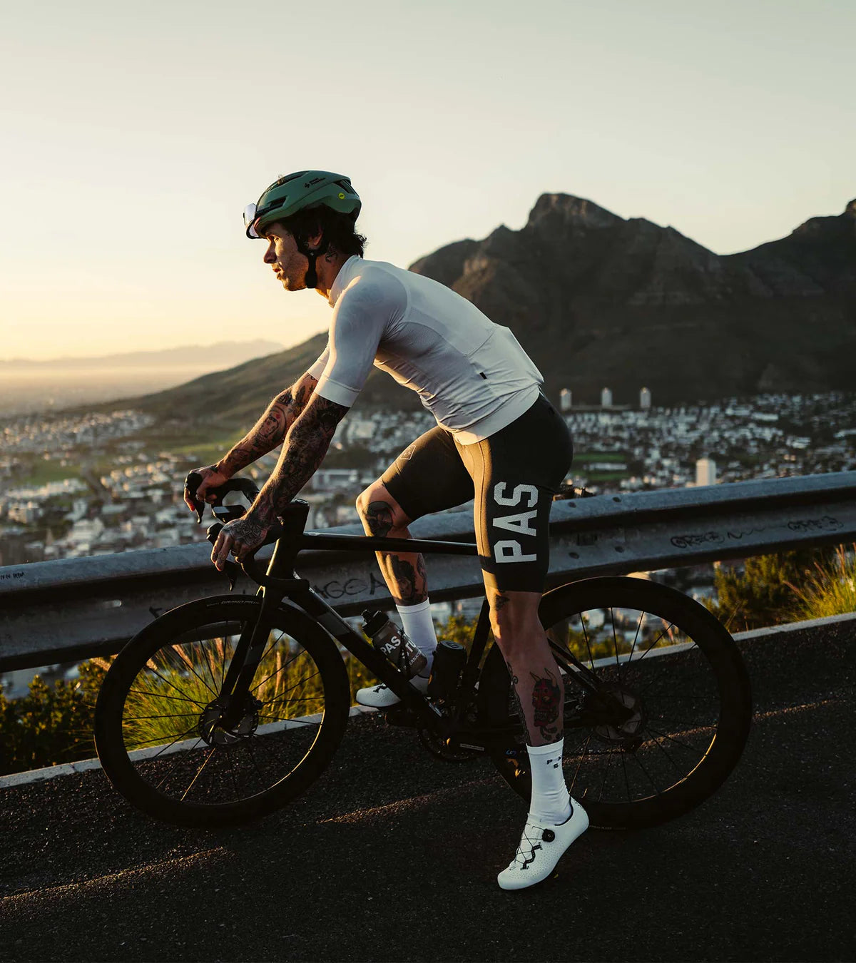 Cyclist riding at sunset wearing white QUOC Escape Road Shoes, showcasing performance footwear for long-distance road cycling.