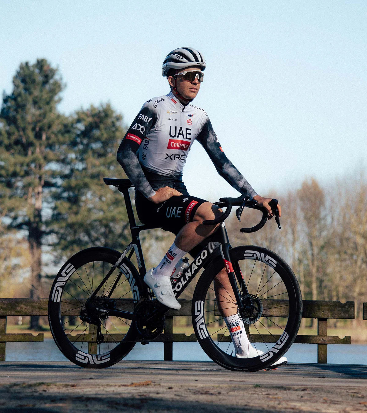 Professional cyclist wearing QUOC M3 Pro Road Shoes while riding a Colnago bike, demonstrating real-world racing application.
