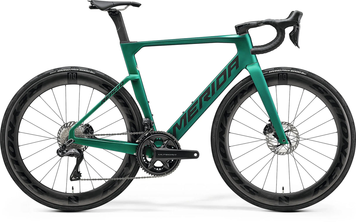 Merida Reacto 8000 Road Bike in metallic green with aerodynamic carbon frame, deep-section wheels, and Shimano Ultegra Di2 groupset for high-speed cycling.