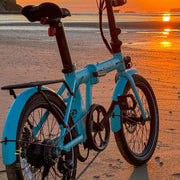 estarli E20.7 Comfort Hybrid E-Bike on beach at sunset, praised by ebiketips for being a neat and affordable electric bike option.