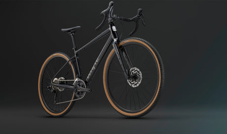Angled view of the Whyte Tourus Gravel Bike in black finish, showcasing disc brakes and drop handlebars for versatile gravel riding.