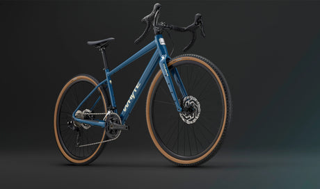Front-side view of the blue Whyte Tourus Gravel Bike highlighting its rugged tires, disc brakes, and ergonomic drop bar design.