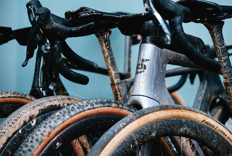 Close-up of multiple Cervelo Aspero-5 SRAM Force AXS 1 Gravel Bikes covered in mud, demonstrating rugged off-road capability.