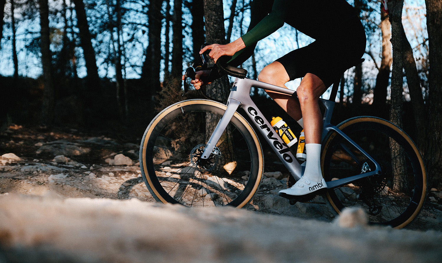 Cyclist riding Cervelo Aspero-5 SRAM Force AXS 1 Gravel Bike on rocky trail, showcasing real-world gravel performance.