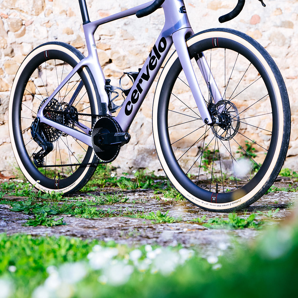 White Cervelo Aspero-5 SRAM Force AXS 1 Gravel Bike on cobblestone path, ideal for high-performance gravel riding.