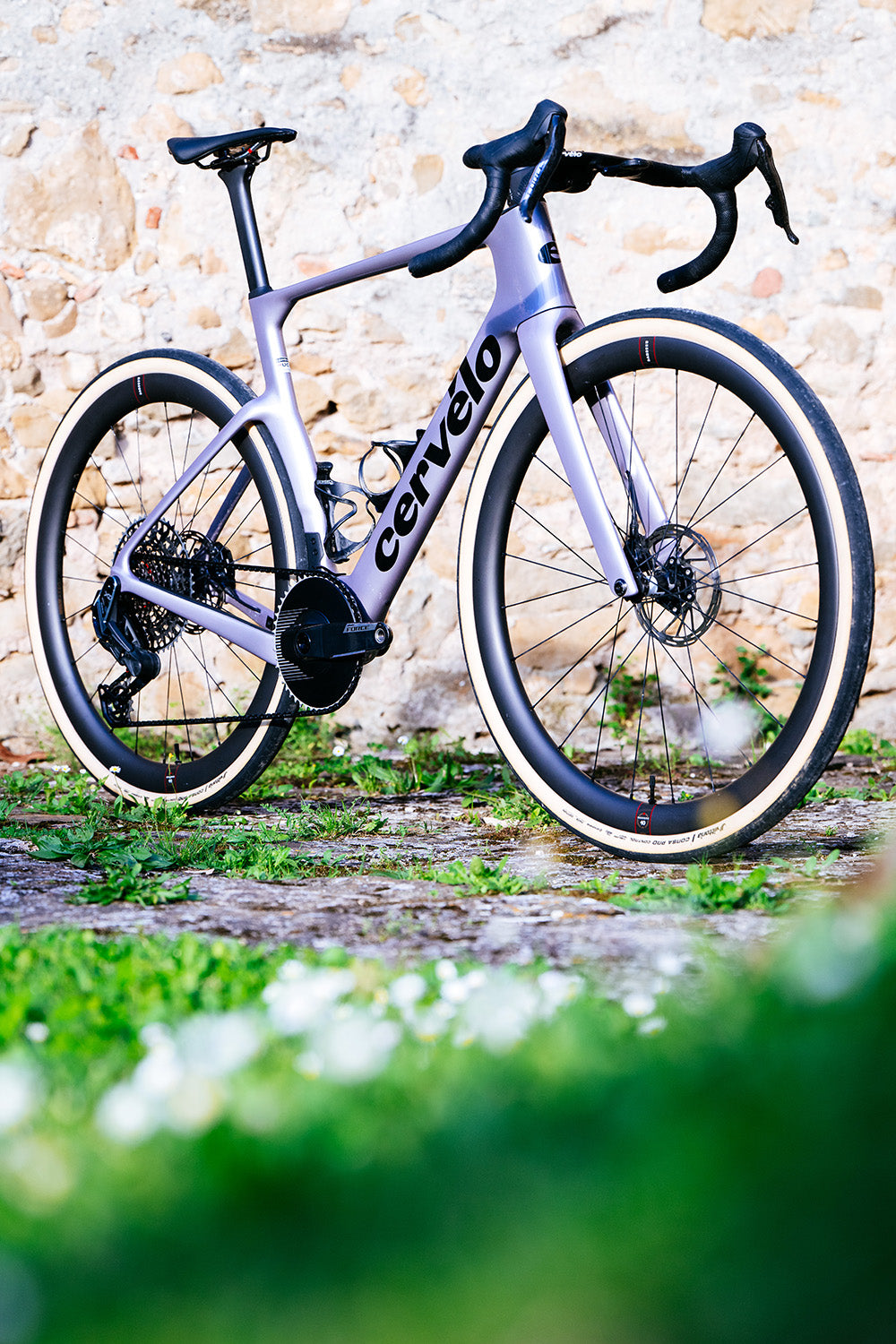 White Cervelo Aspero-5 SRAM Force AXS 1 Gravel Bike on cobblestone path, ideal for high-performance gravel riding.
