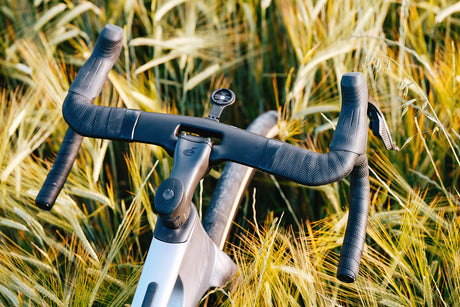 Top view of Cervelo Aspero-5 SRAM Force AXS 1 Gravel Bike handlebars in a wheat field, showcasing integrated cockpit design.