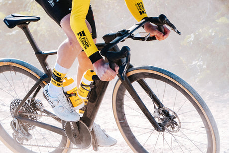 Cyclist riding Cervelo Aspero-5 SRAM Force AXS 1 Gravel Bike on dusty trail, demonstrating race-level gravel performance.