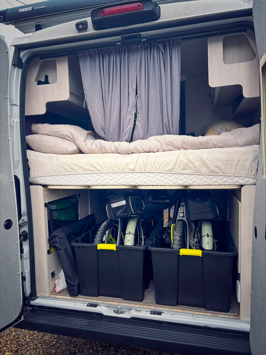 Folded estarli E20.8 Play Hybrid E-Bikes neatly packed in a camper van storage compartment, ideal for mobile lifestyles.