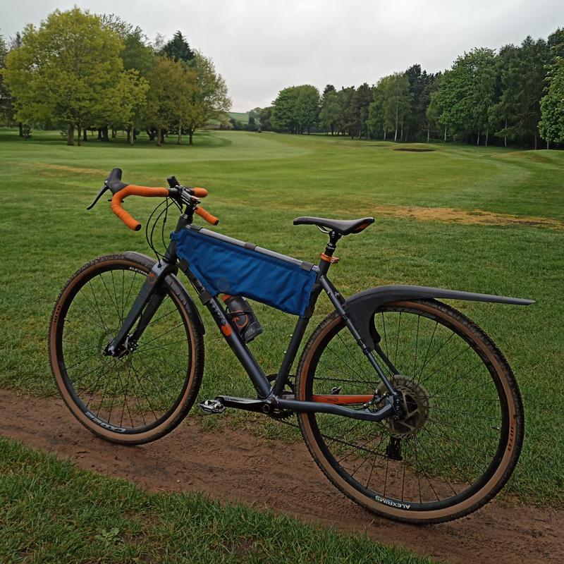 Gravel bike on grass with a Mudhugger Gravel Hugger rear mudguard fitted to the seat stays