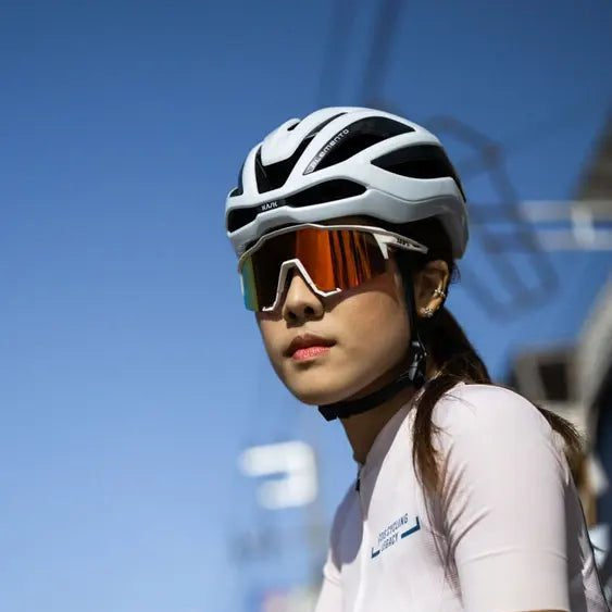 Cyclist wearing a white Kask Elemento road helmet and sunglasses