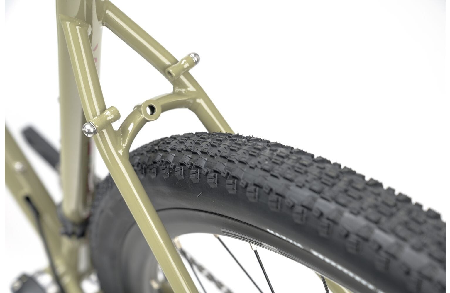 Knobby rear tire and seat stay detail of the 2025 Genesis Croix De Fer 30 Gravel Bike built for traction on rough gravel paths.