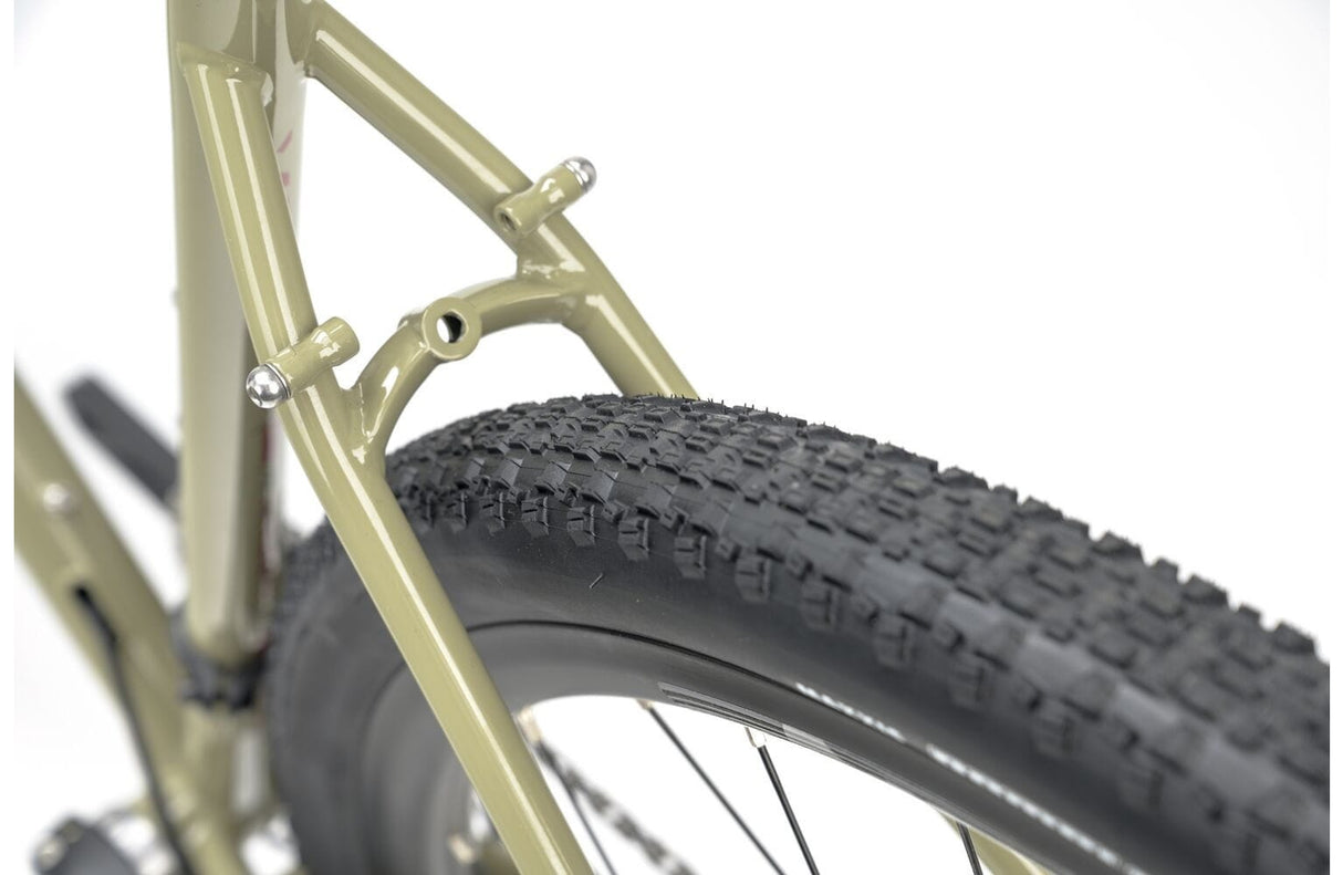 Knobby rear tire and seat stay detail of the 2025 Genesis Croix De Fer 30 Gravel Bike built for traction on rough gravel paths.