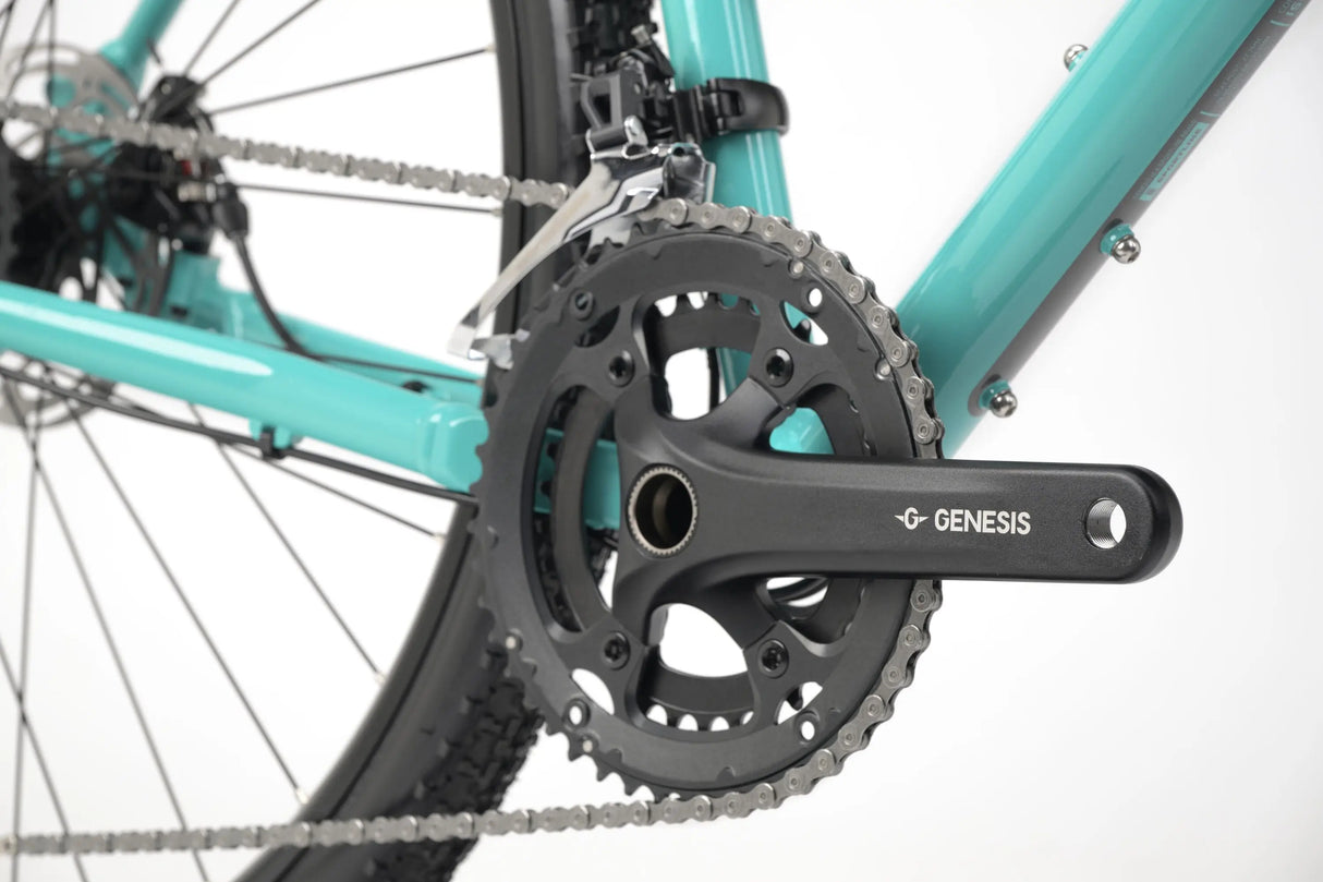 Close-up of John Teal Genesis CDA 20 Gravel Bike drivetrain and crankset with black chainrings and pedals.