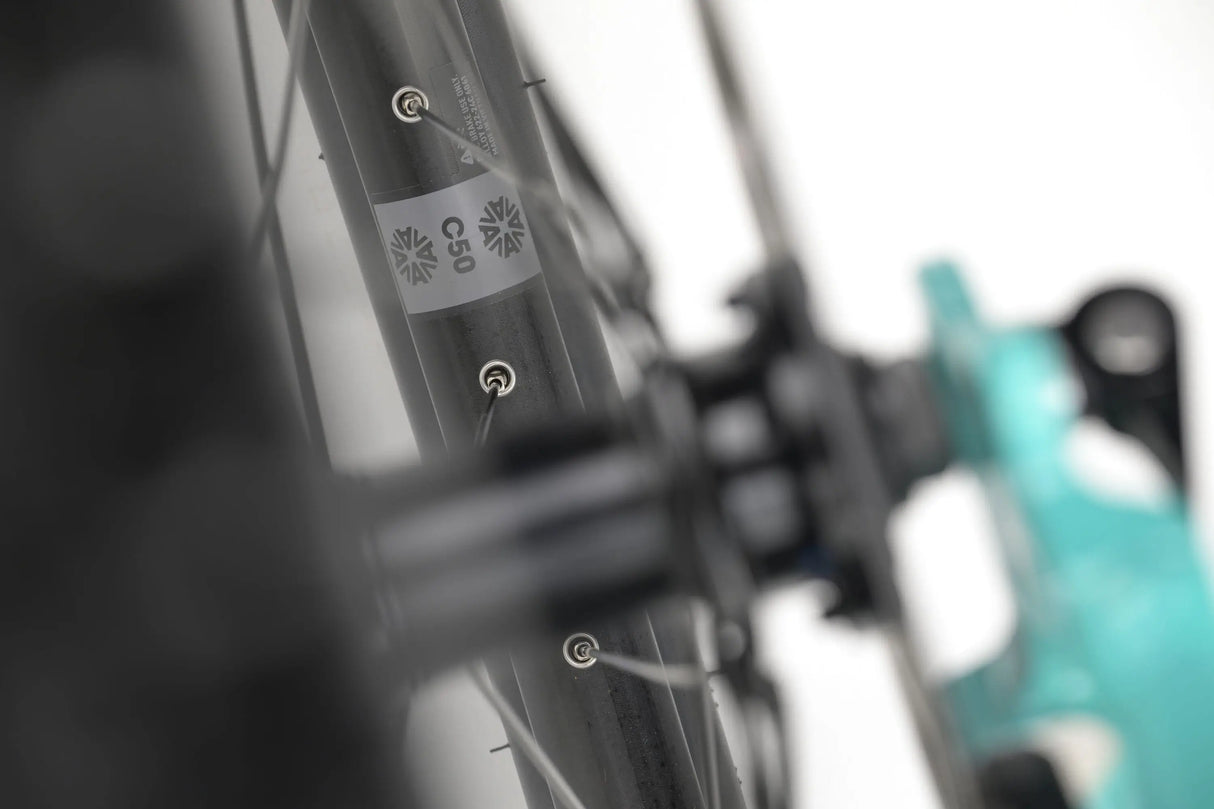 Close-up of a teal Genesis CDA 20 gravel bike frame showing brake mounts and textured detailing.