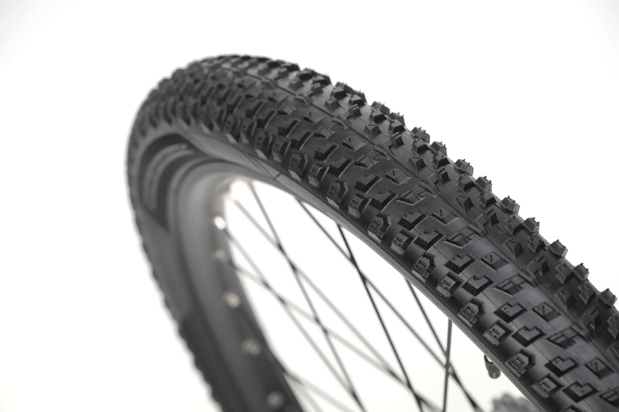 24-inch knobby tire on black rim with silver spokes for kids gravel bike.