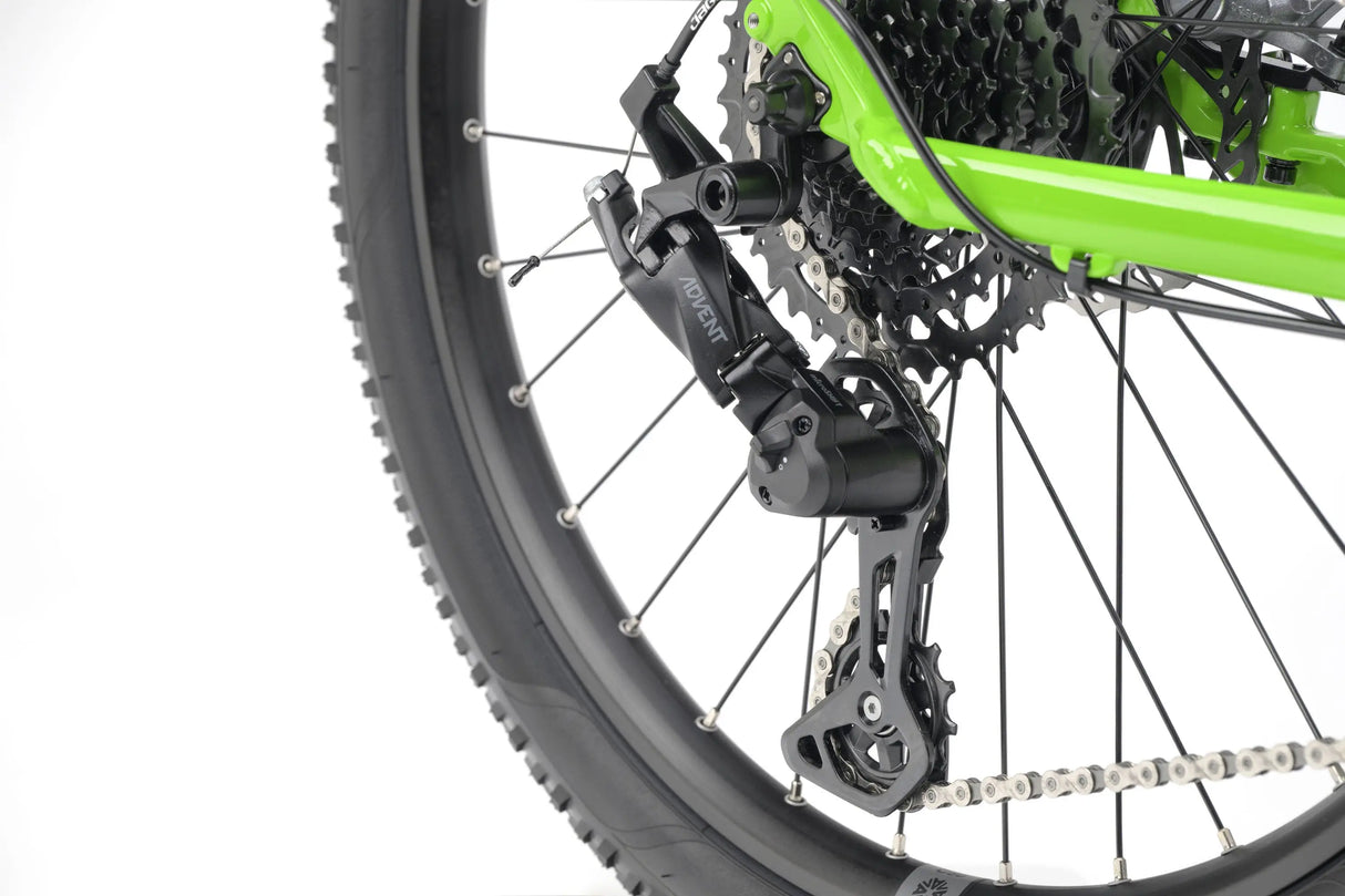 Close-up of black rear derailleur and cassette on bright green kids' gravel bike wheel.