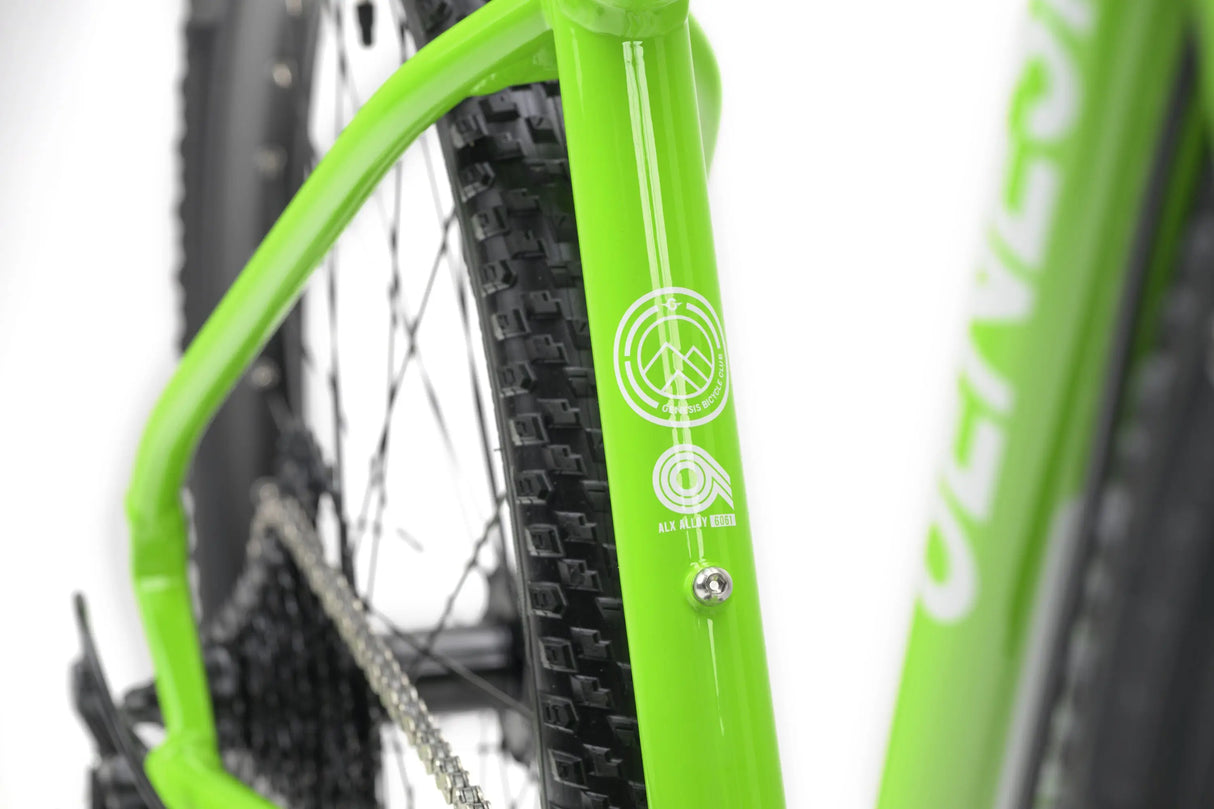 Close-up of bright green Genesis CDA JNR kids gravel bike frame highlighting rear tire and branding details.