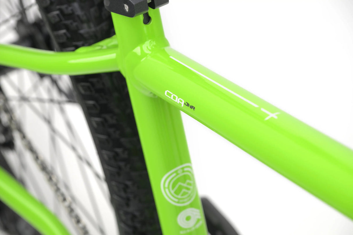 Bright green Genesis CDA JNR kids gravel bike frame detail with black tire tread.