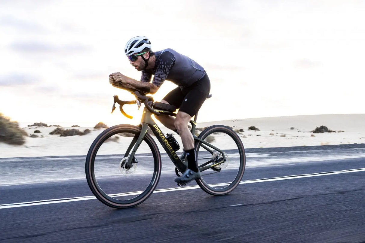 Cyclist riding a bicycle on a road with a scenic background