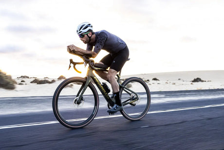 Cyclist riding a bicycle on a road with a scenic background