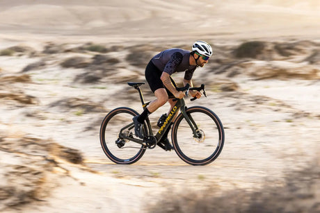 Cyclist riding a bicycle on a desert landscape