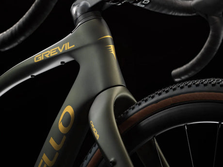 Close-up of a bicycle frame with 'Grevil' branding on a dark background