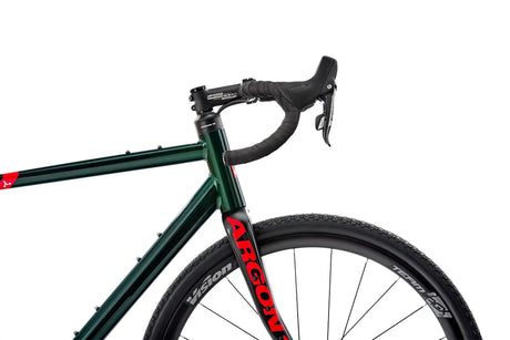 Side view of Argon 18 Grey Matter Apex XPLR Gravel Bike front frame and fork, highlighting branding and robust wheel setup for gravel performance.