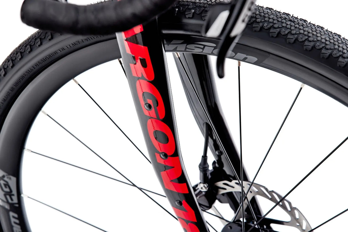 Detailed shot of Argon 18 Grey Matter Apex XPLR Gravel Bike fork and tire, featuring Vision wheels and disc brakes for superior grip and stopping power.
