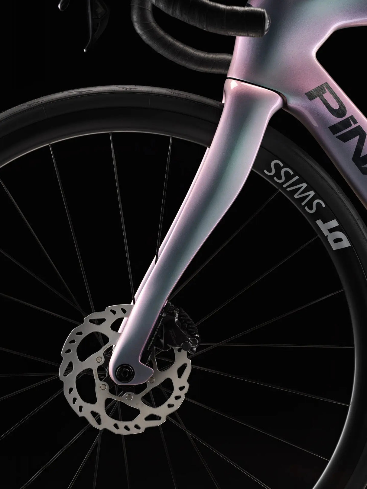 Close-up of a bicycle wheel with a pink frame on a black background