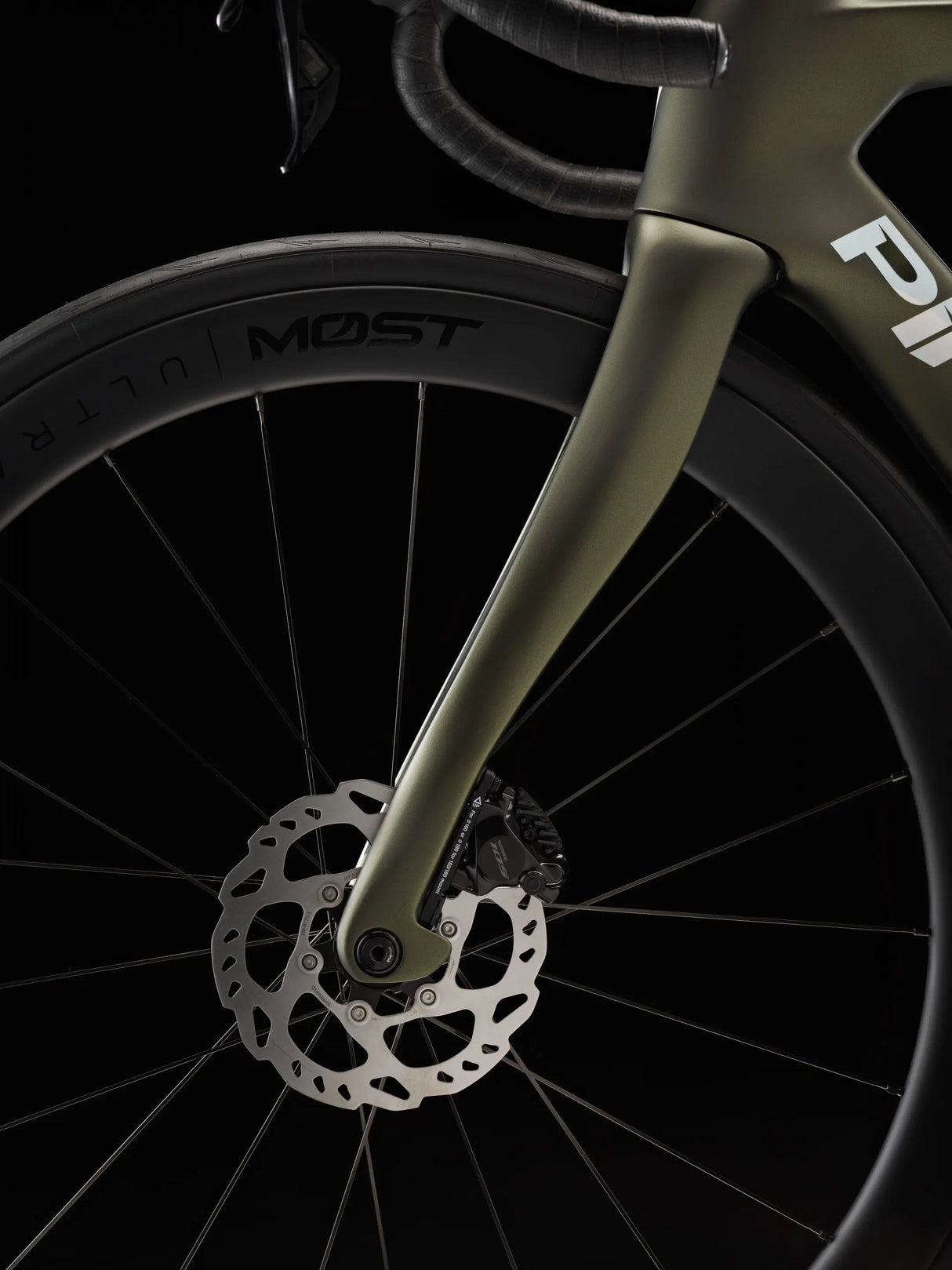 Close-up of a bicycle wheel with 'MOST' branding on a black background