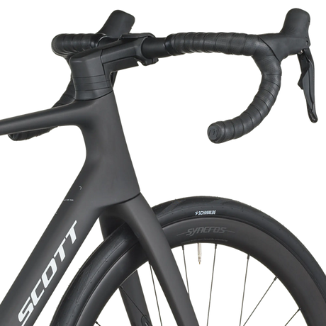 Close-up of a black bicycle with 'Scott' branding on a white background