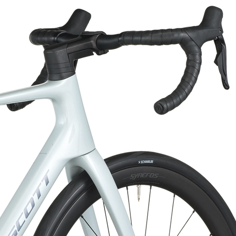 Close-up of a bicycle handlebar with white frame and black tires on a white background