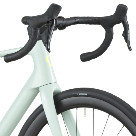 Close-up of a bicycle handlebar with a light green frame and black components on a white background.