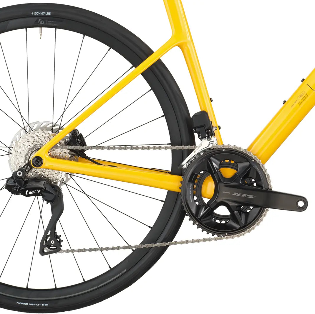 Close-up of a yellow bicycle with chain and gear system on a white background