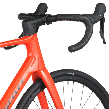 Close-up of a red bicycle with black handlebars on a white background