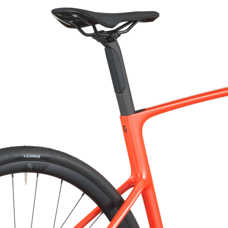 Close-up of a bicycle with an orange frame and black seat on a white background