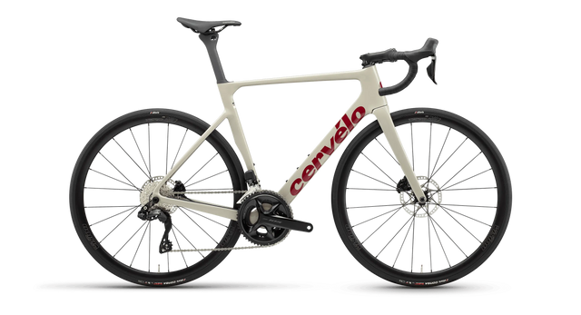 Cervelo Soloist 105 Di2 Road Bike in sand color with red logo, featuring Shimano Di2 shifting and disc brakes for high-speed road cycling performance.