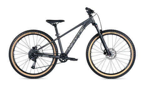 The 403 V3 by Whyte is a mountain bike featuring a matt granite color, equipped with a flat handlebar, disc brakes, and chunky off-road tires. The bike boasts a minimalist design without any additional accessories or visible branding. It has tan-colored sidewalls on the wheels and a sleek, sturdy frame.