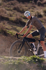 Rider climbing a steep gravel slope on an Argon 18 Anti Matter gravel bike