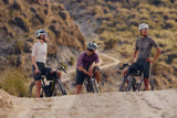 Three riders standing with Argon 18 Anti Matter gravel bikes on a ridge in dry hills