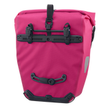Cyber pink Ortlieb Back-Roller 20L pannier bag with black mounting hardware and reflective side patch.
