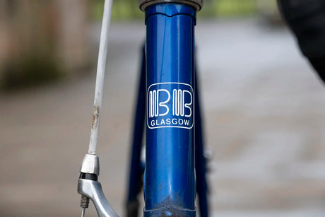 Front badge of a blue Billy Bilsland bike frame with 'BB Glasgow' logo, tying into the 45th Anniversary Jersey theme.