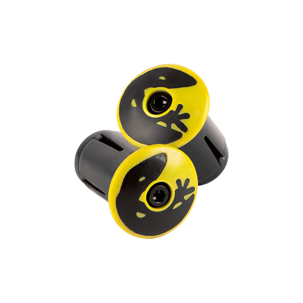 The Lizard Skins DSP V2 2.5mm Bar Tape by Lizard Skins is a pair of durable black and yellow handlebar grips that showcases a distinctive eyeball design on the end caps, featuring a black eye encompassed by a yellow area. They are displayed against a white background.