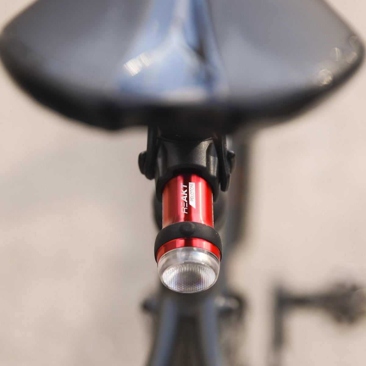 Exposure BoostR Mk3 rear light seen from behind under a saddle, showing the lens