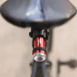 Exposure BoostR Mk3 rear light seen from behind under a saddle, showing the lens