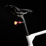 Exposure TraceR Mk4 rear light lit red on the seatpost of a bike in the dark