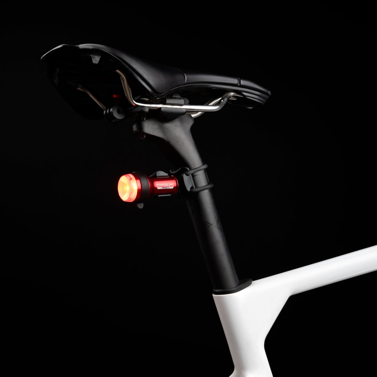 Exposure TraceR Mk4 rear light lit red on the seatpost of a bike in the dark