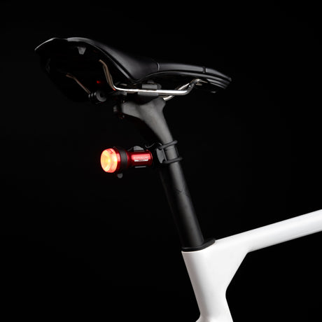 Exposure TraceR Mk4 rear light lit red on the seatpost of a bike in the dark